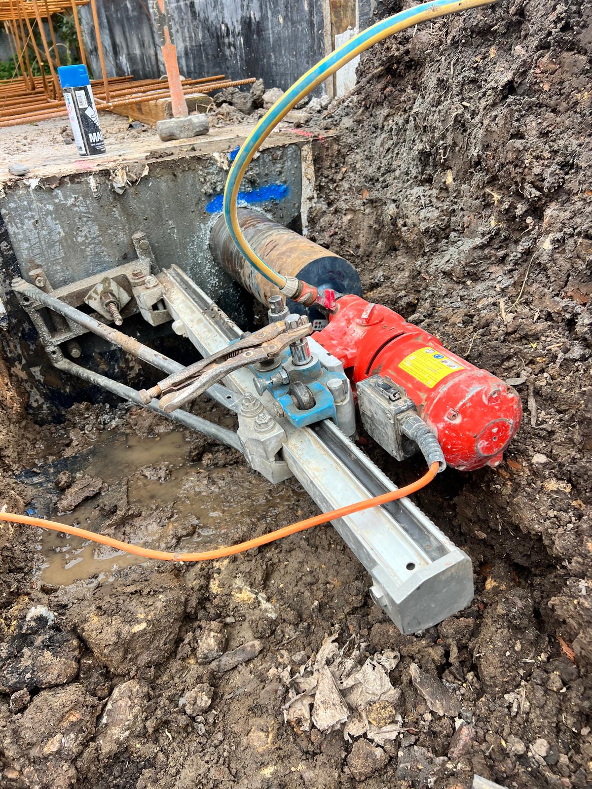 Core drill positioned for an accurate concrete service penetration